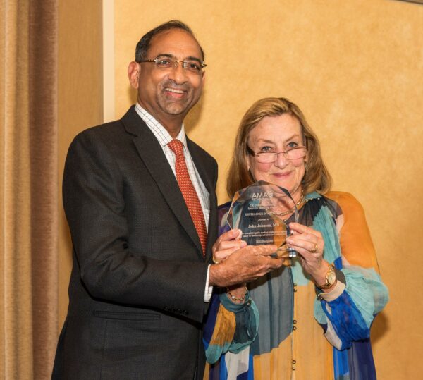 Dr. Johnson receives an Excellence award from AMAF President Dr. Nancy Mueller